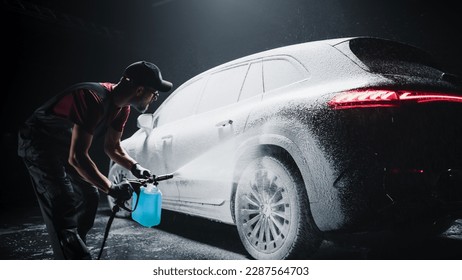 Professional Car Wash Specialist Spraying Smart Foam to Prepare a Modern Black Electric SUV with Contemporary Design for Sale at a Dealership Car Center. Commercial Studio Footage for Advertising