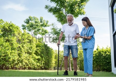 Professional caregiver taking care of elderly man at home.elderly man walking with nurses or caregivers to help.Concept of health for the elderly.