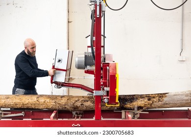 Professional carpenter cutting raw wood on the table with electric band saw, cutting wooden board at sawmill, carpentry manufacturing concept - Powered by Shutterstock