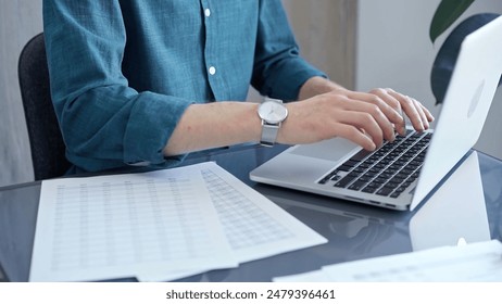 Professional casual dressed businessman is working on laptop at office grey and glass desk. Close-up of an adult's hands typing on a keyboard. Business people - Powered by Shutterstock