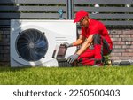Professional Caucasian Heat Pumps Technician in His 40s Installing New Residential Modern Heating Device. HVAC Industry Theme.