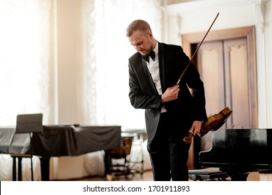 Professional Caucasian Male Violinist In Suit Bows To The Audience At The End Of Performance, Classical Music Performer On A Stage. Music, Instruments Concept