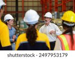 Professional Caucasian manager engineer wearing safety hardhat is training industry worker, workshop factory operator, mechanical engineering team production in heavy industrial manufacture factory.