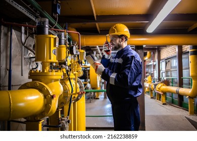 Professional caucasian refinery worker in safety equipment checking gas pipeline installation and pressure. - Shutterstock ID 2162238859