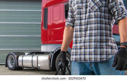 Professional CDL Semi Truck Driver In His 40s Preparing For Another Trip In Front Of His Modern Red Tractor Truck. Commercial Driver License Theme.