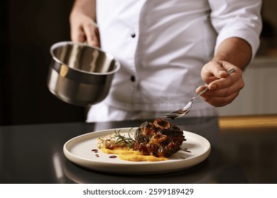 Professional chef adding sauce to delicious dish at table indoors, closeup