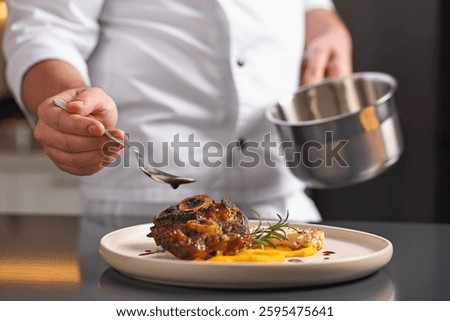 Professional chef adding sauce to delicious dish at table indoors, closeup
