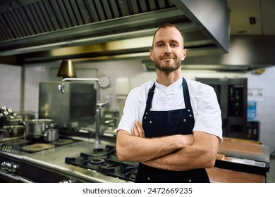 Professional chef with arms crossed in the kitchen looking at camera. Copy space. - Powered by Shutterstock