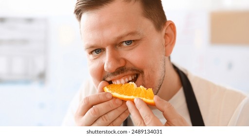 Professional Chef Bite Orange Slice Portrait. Vlogger Man Eating Juice Citrus with Smile on Face. Person Put Yellow Fruit to Mouth. Healthy Food Lifestyle. Male with White Teeth Looking at Camera Shot - Powered by Shutterstock