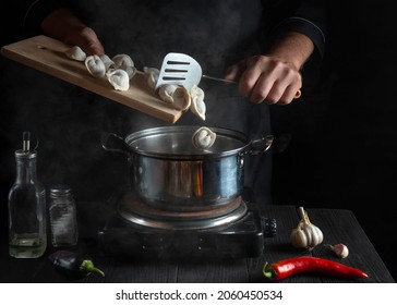 Professional chef cooks Pelmeni or meat dumplings in a saucepan in the restaurant kitchen. Close-up of the hands of cook during work - Powered by Shutterstock