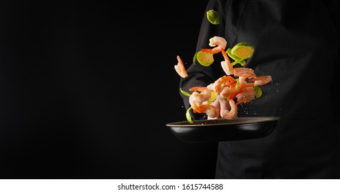 A professional chef cooks shrimp in a pan with brussels sprouts, vegetables. Cooking seafood, healthy vegetarian food and food on a dark background. Freezing in motion. Horizontal view. Banner.