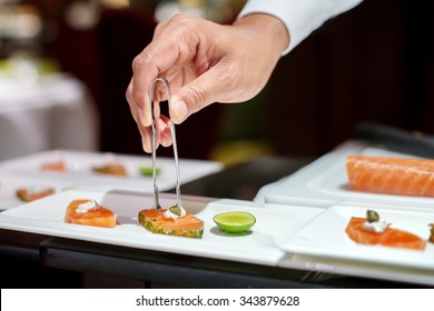 Professional Chef Decorating Caper On Sliced Salmon