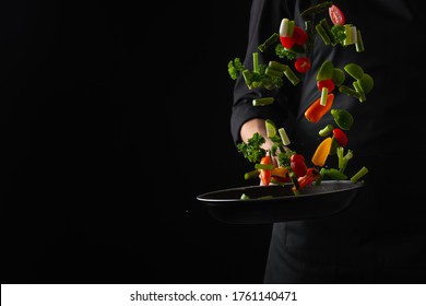 Professional Chef Fry Vegetables In A Pan, Freeze In Motion, On A Black Background, Banner, Veggie Food, Tasty And Wholesome Food