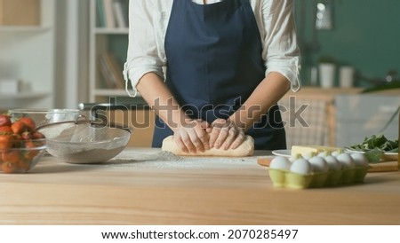 Professional Chef Kneads Dough for Baking on a Wooden Kitchen Table. The Process of Making a Beautiful Dough. Homemade Cakes for a Pastry Coffee Shop. Close-up.