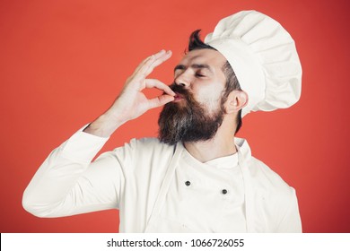 Professional chef man showing sign for delicious. Male chef in white uniform with perfect sign. Serious satisfied bearded chef, cook or baker gesturing excellent. Cook with taste approval gesture.