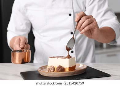 Professional chef pouring chocolate cream onto delicious cake at white marble table in kitchen, closeup - Powered by Shutterstock