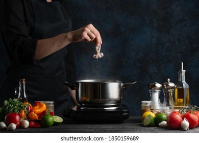 Professional Chef Puts Baby Octopus Into Boiling Water. Backstage Of Preparing Seafood On Dark Blur Background. Frozen Motion. Concept Of Exotic Asian Cuisine.