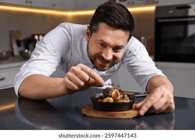 Professional chef serving dish at table indoors