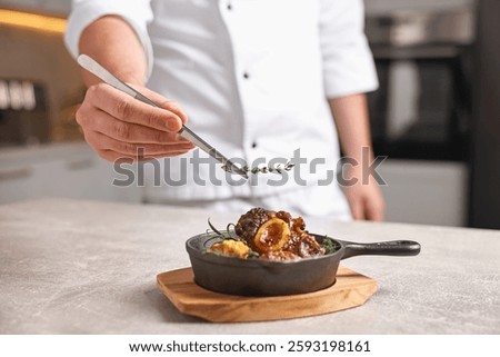 Professional chef serving dish at table indoors, closeup