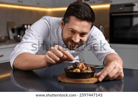 Professional chef serving dish at table indoors