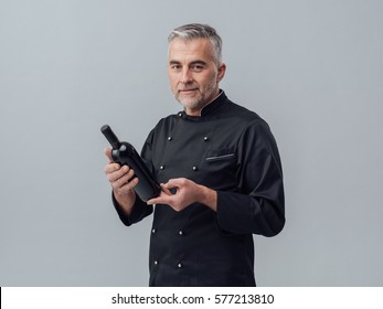 Professional Chef And Sommelier Holding A Bottle Of Wine And Reading A Label, Wine Culture Concept