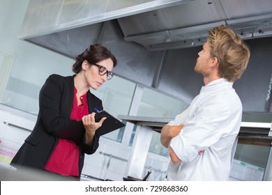 professional chef supervising cleanness of kitchen - Powered by Shutterstock