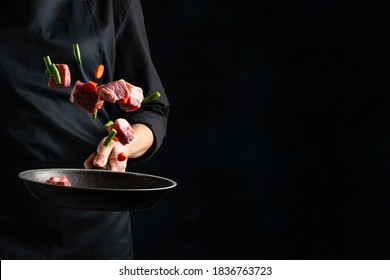 The professional chef tossed chopped pork or beef with vegetables in frying pan on black background. Backstage of cooking grilled meat for dinner. Food concept. Frozen motion. Asian cuisine. - Powered by Shutterstock