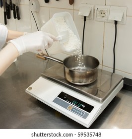 Professional chef is weighing some ingredients to cook a dish