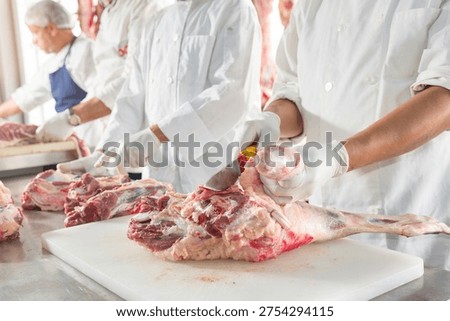 Professional chef in white gloves precisely slicing premium raw red meat on a white cutting board for gourmet preparation