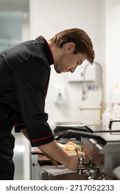 Professional chef writing notes in notebook onkitchen