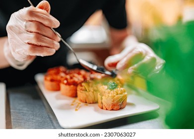 professional chef's hands making sushi roll in a restaurant kitchen - Powered by Shutterstock