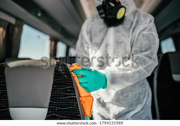 Professional chemical cleaning of bus seats.\
Bus disinfection. Exterminator in\
workwear.