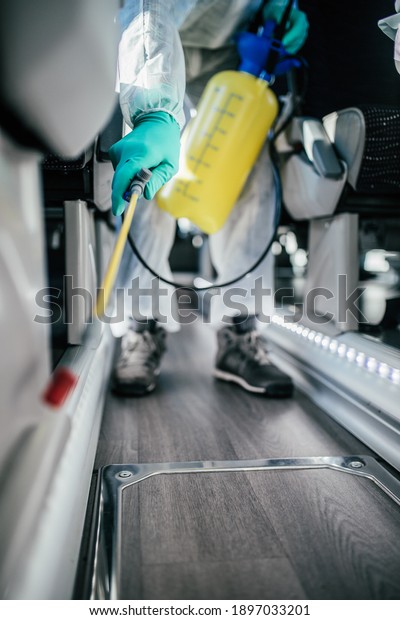 Professional chemical cleaning bus seats. Bus\
disinfection. Exterminator in\
workwear.