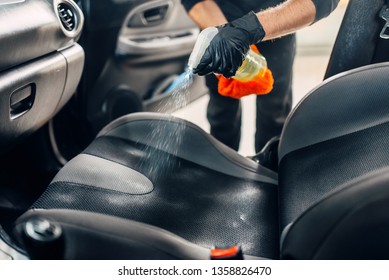 Male using professional steam vacuum for dirty car interior