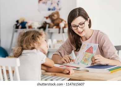 A Professional Child Education Therapist Having A Meeting With A Kid In A Family Support Center.