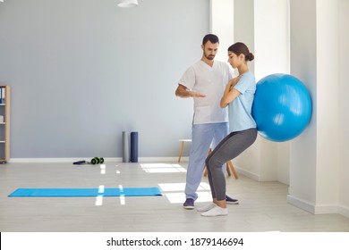 Professional chiropractor or osteopath controlling womans position during exercising with fitness ball near wall at rehabilitation theapy in manual therapy clinic. Chiropractor during work concept - Powered by Shutterstock