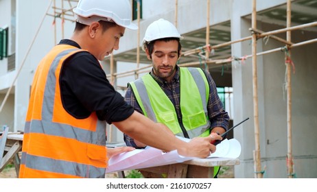 Professional Civil Engineer Foreman Opening Paperwork To Assign Responsibility To Young Engineer Worker Working With Team At Construction Site Making A Check On Building, Civil Engineering Concept