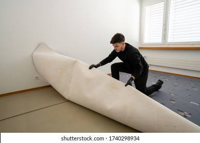 Professional Cleaner From A Facility Management Company Removes Ugly Old Carpet In A Bedroom During Cleaning And Renoavation Work