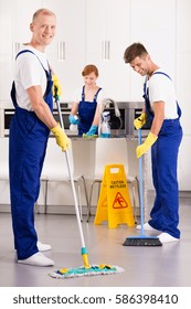 Professional cleaners in the kitchen with broom and mop