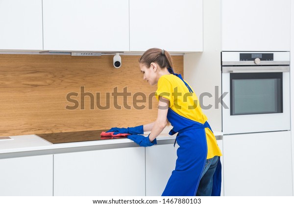 professional
cleaning service. Two women in working uniform, in aprons, divide
the cleaning of the kitchen of a private house, cottage. washing
the refrigerator, tap, sink. Wash
floor.