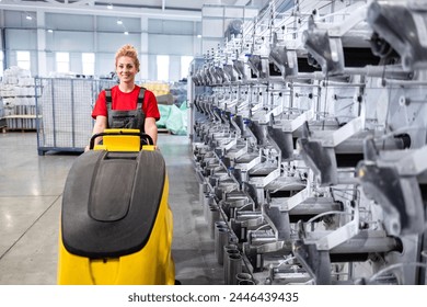 Professional cleaning service. Worker operating industrial floor cleaning machine inside factory. - Powered by Shutterstock