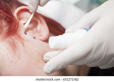 Professional Cleaning The Wound After Piercing A Young Girl Ear. Tragus Type