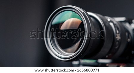 Professional close-up of a camera lens with sharp glass reflection.