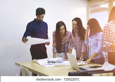Professional coach checking blueprint created by female architects during consultancy meeting.Beautiful coworkers enjoying brainstorming session making decision for design project cooperating