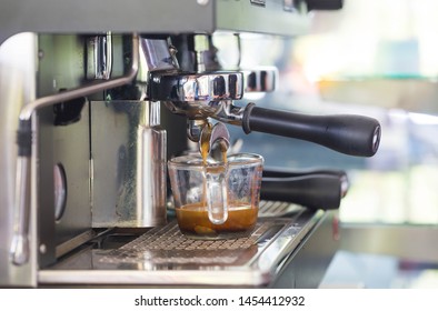 Professional coffee machine with a cup brewing and pouring espre