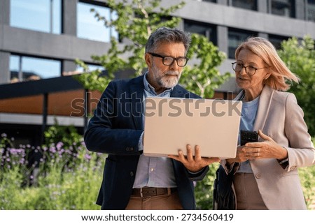 Professional colleagues using AI tools for business discussion outside corporate office, teamwork, digital technology and project planning