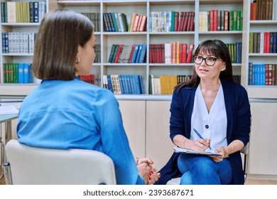 Professional college counselor talking to young female student - Powered by Shutterstock