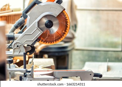 Professional compound mitre circular saw at emnty woodcraft carpentry workshop. carpenter woodworks manufacture background. Electric power tools machinery equipment. Safety covered steel jigsaw blade - Powered by Shutterstock - Get 15% off with code: PIKWIZARD15