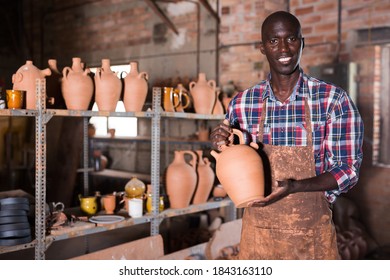 Professional Confident African American Potter Proffering Goods In Pottery Shop