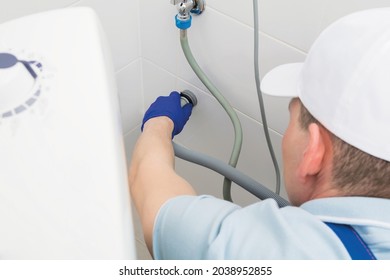 Professional Connection Of A New Washing Machine By A Service Worker, Side View